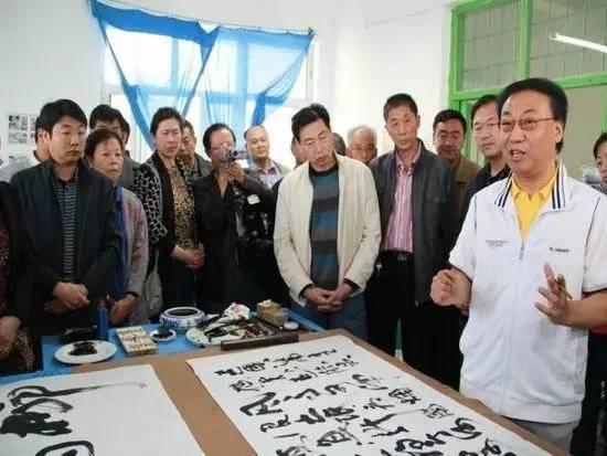 2012年,曹永正回到新疆,揮筆作詩(shī)一首。(右一為曹永正)